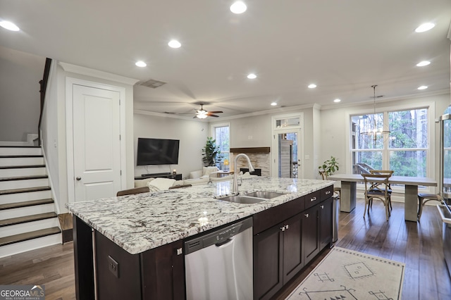 kitchen with a sink, dark wood-type flooring, stainless steel dishwasher, and a kitchen island with sink