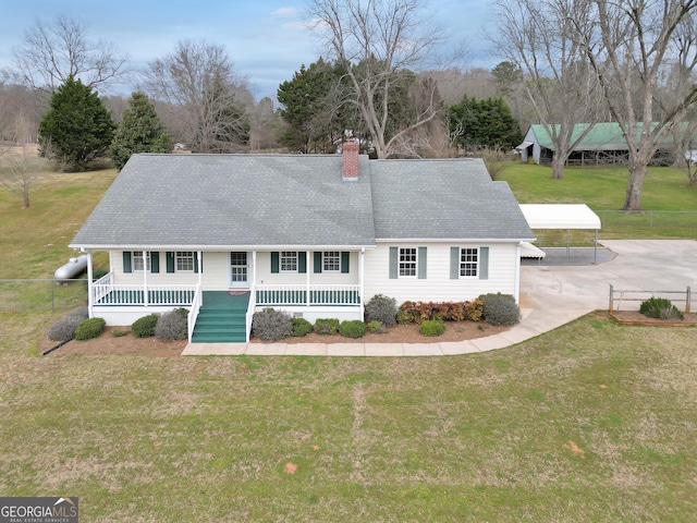 exterior space with a front lawn, covered porch, roof with shingles, and a chimney