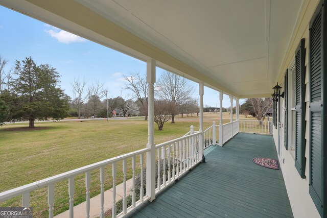wooden deck featuring a yard and covered porch