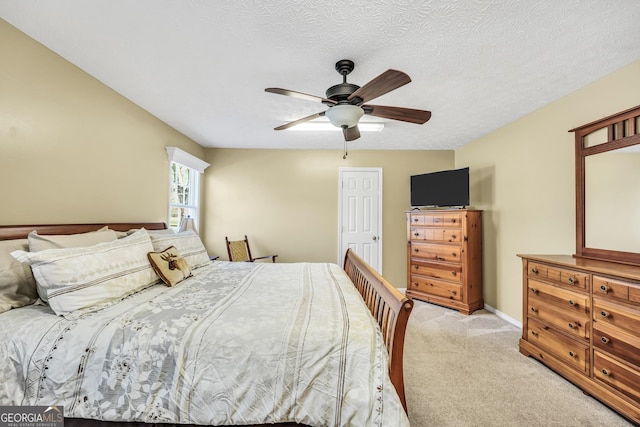 bedroom featuring a ceiling fan, light colored carpet, baseboards, and a textured ceiling