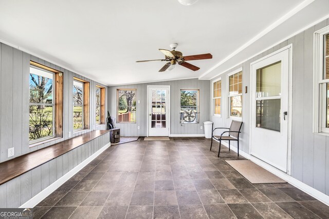 unfurnished sunroom with lofted ceiling and a ceiling fan