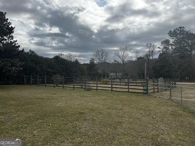 view of yard with a rural view and fence