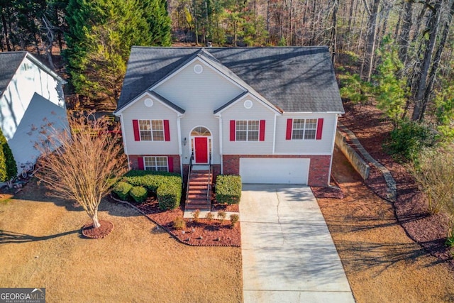 bi-level home featuring brick siding, driveway, and a garage