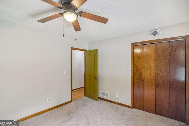 unfurnished bedroom with visible vents, ceiling fan, baseboards, carpet, and a closet