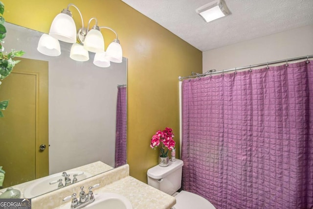 bathroom featuring vanity, toilet, visible vents, and a textured ceiling