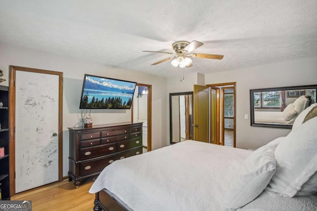 bedroom featuring light wood-style flooring, a ceiling fan, and a textured ceiling