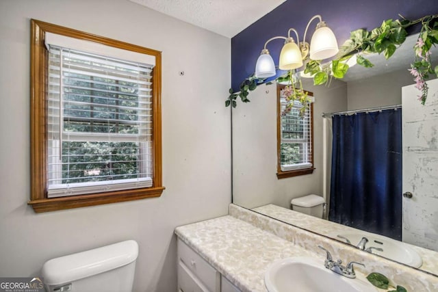 full bathroom with vanity, curtained shower, toilet, and a textured ceiling