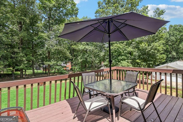 wooden terrace with outdoor dining area and a yard