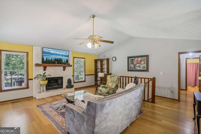 living room with a wealth of natural light, lofted ceiling, and wood finished floors