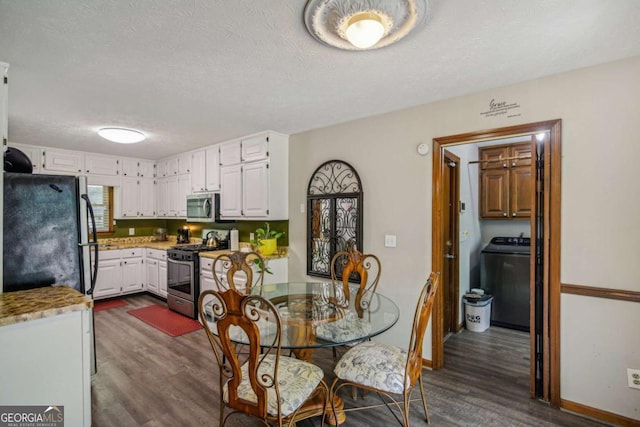 dining room featuring baseboards, a textured ceiling, washer / dryer, and dark wood finished floors