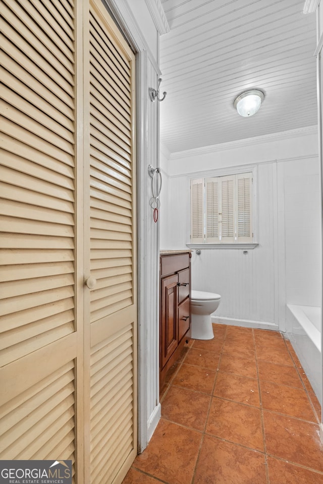 bathroom featuring tile patterned floors, toilet, a closet, crown molding, and vanity