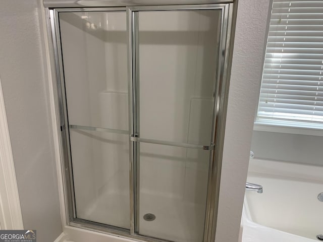 full bathroom featuring a garden tub and a stall shower