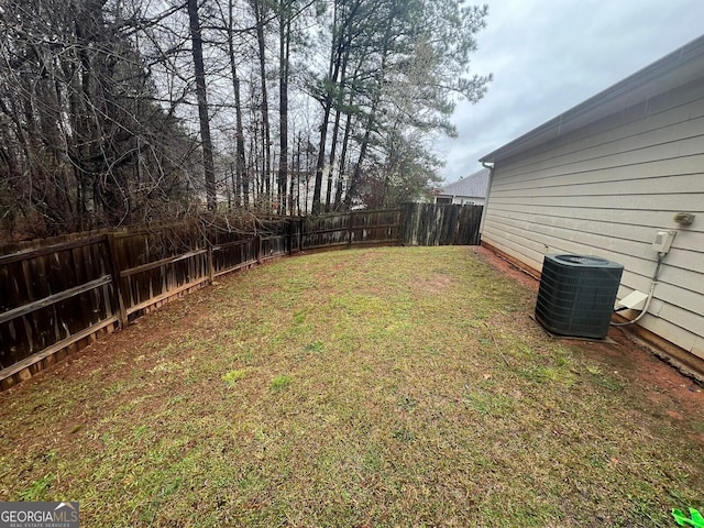 view of yard with a fenced backyard and central AC