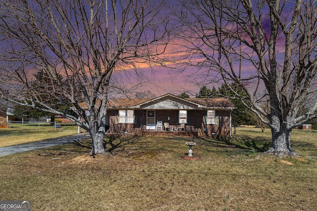 view of front of property with brick siding, crawl space, a lawn, and covered porch