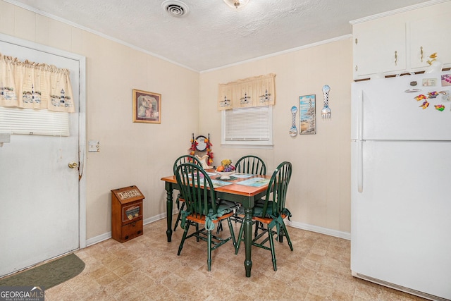 dining area with crown molding, baseboards, visible vents, and a textured ceiling