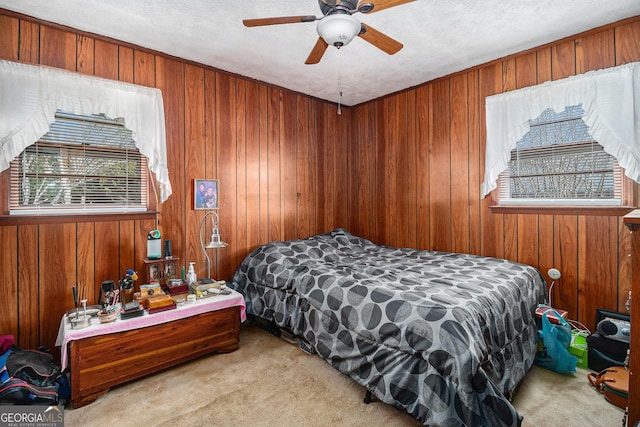 bedroom featuring wood walls, a ceiling fan, and carpet floors