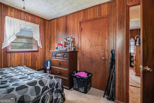 bedroom with wooden walls, carpet, and a textured ceiling