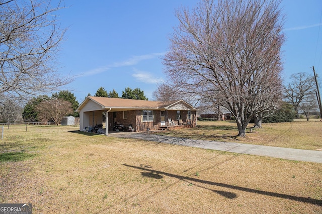 view of front of house with a front lawn, a porch, dirt driveway, fence, and brick siding