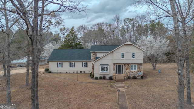 view of front of house featuring stone siding and a shingled roof