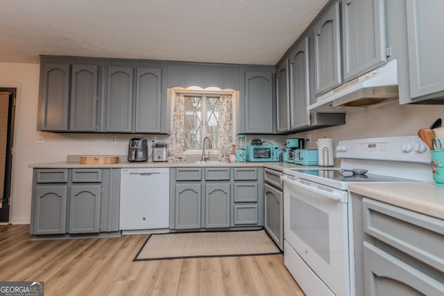 12701 Ga Highway 96 E, Fort Valley, GA 31030 - kitchen featuring white appliances, under cabinet range hood, light wood-type flooring, light countertops, and a textured ceiling