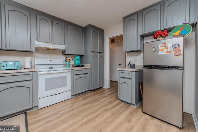 12701 Ga Highway 96 E, Fort Valley, GA 31030 - kitchen featuring freestanding refrigerator, electric stove, under cabinet range hood, light wood-type flooring, and light countertops