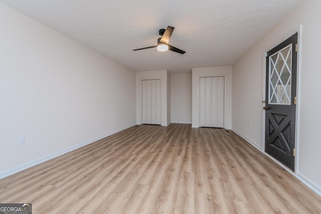 12701 Ga Highway 96 E, Fort Valley, GA 31030 - unfurnished bedroom featuring light wood-style floors, two closets, and a ceiling fan