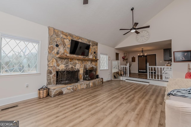 12701 Ga Highway 96 E, Fort Valley, GA 31030 - unfurnished living room featuring ceiling fan, a chandelier, wood finished floors, a stone fireplace, and high vaulted ceiling