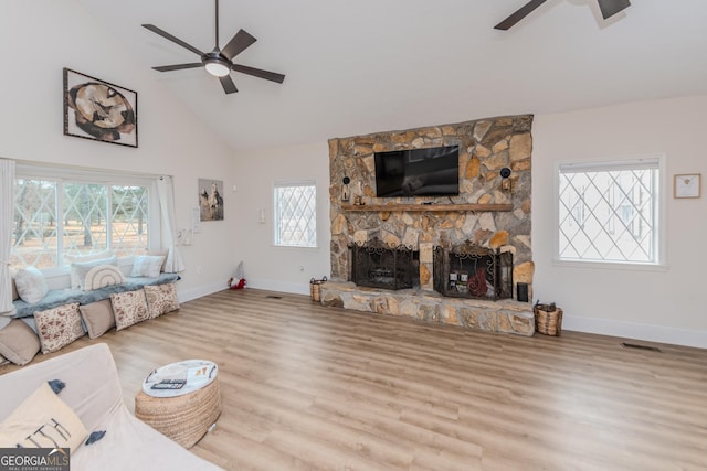 12701 Ga Highway 96 E, Fort Valley, GA 31030 - living room with a ceiling fan, wood finished floors, high vaulted ceiling, and a stone fireplace