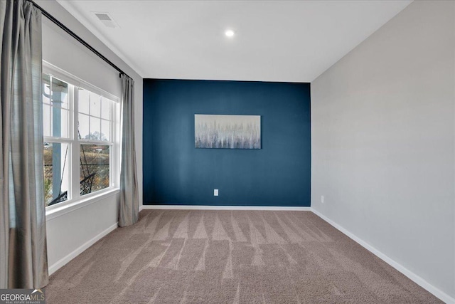 empty room featuring visible vents, carpet, and baseboards