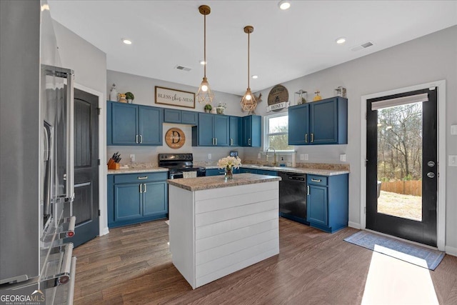 kitchen with visible vents, blue cabinetry, dark wood-style flooring, a sink, and appliances with stainless steel finishes