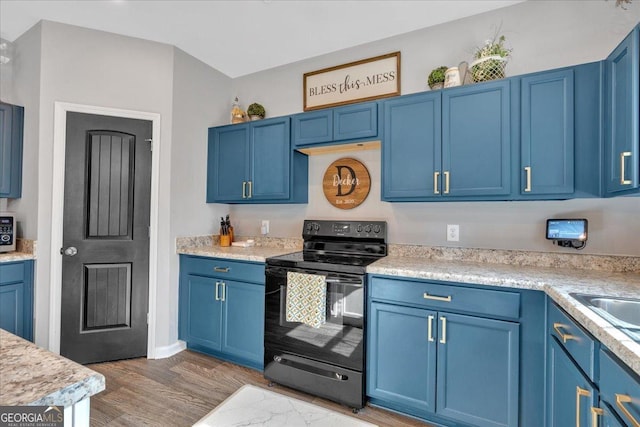 kitchen featuring blue cabinetry and black range with electric stovetop