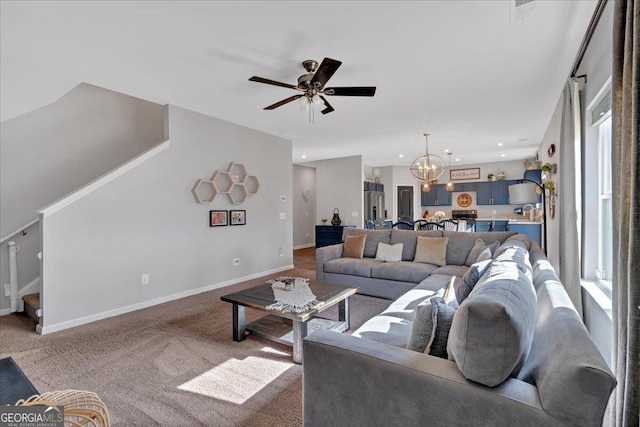 living room with ceiling fan with notable chandelier, recessed lighting, stairway, carpet floors, and baseboards