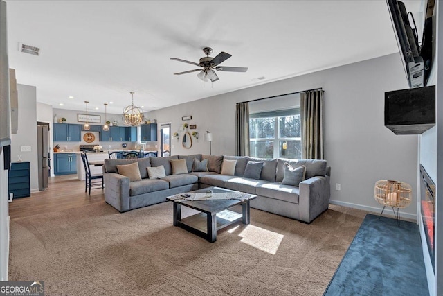 living room with recessed lighting, visible vents, baseboards, and ceiling fan with notable chandelier