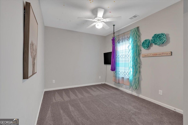 unfurnished room with carpet flooring, baseboards, and a ceiling fan