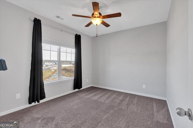 carpeted empty room featuring baseboards, visible vents, and ceiling fan