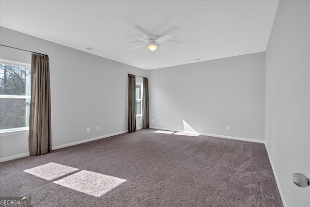 carpeted spare room featuring a healthy amount of sunlight, baseboards, and ceiling fan