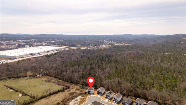 birds eye view of property with a mountain view and a wooded view