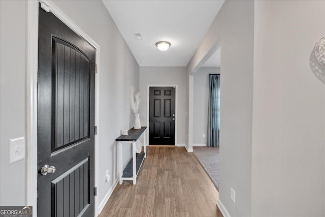 interior space featuring visible vents, baseboards, and wood finished floors