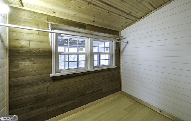 interior space with wooden walls, wood finished floors, wooden ceiling, and vaulted ceiling