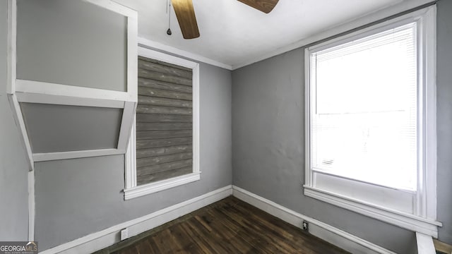 unfurnished room featuring baseboards, plenty of natural light, dark wood-style floors, and a ceiling fan