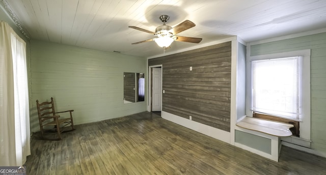 interior space featuring hardwood / wood-style floors, wooden ceiling, wood walls, and ceiling fan