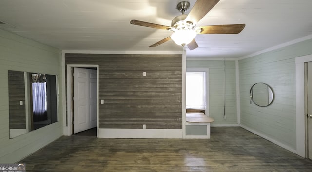 spare room featuring ceiling fan, wooden walls, and wood finished floors