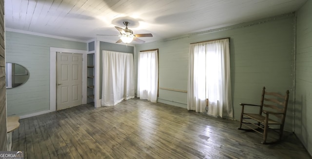 bedroom with wood walls, a ceiling fan, and hardwood / wood-style floors