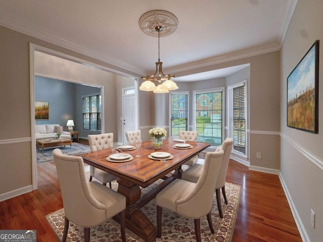 dining area with ornamental molding, an inviting chandelier, baseboards, and wood finished floors