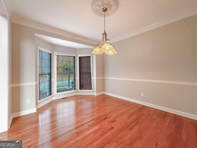 spare room featuring visible vents, baseboards, light wood-style floors, and ornamental molding