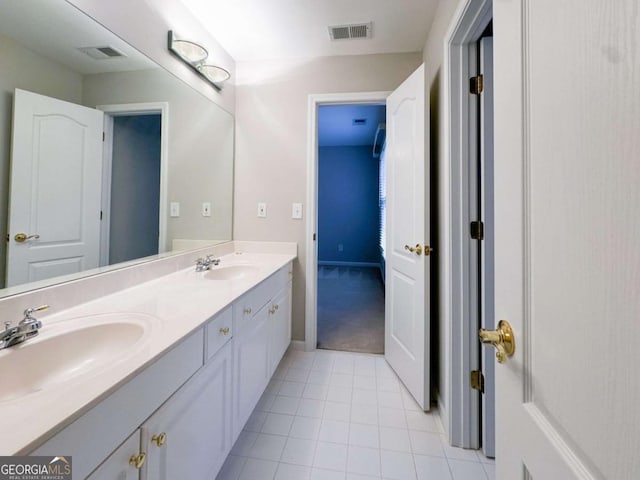 bathroom featuring a sink, visible vents, double vanity, and tile patterned flooring