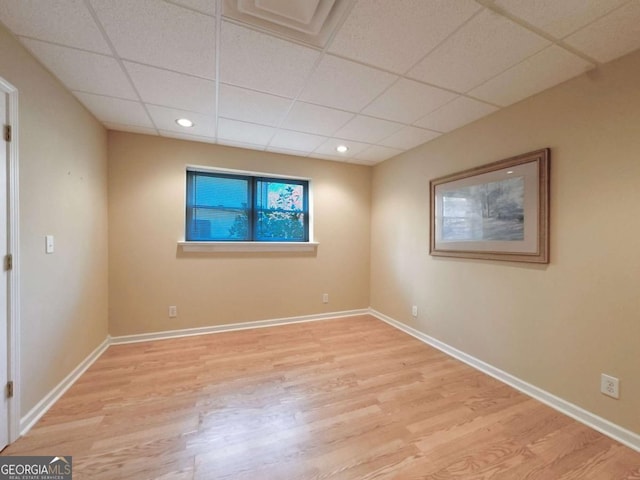 empty room featuring recessed lighting, wood finished floors, baseboards, and a paneled ceiling