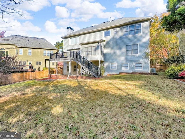 back of property with stairs, fence, a lawn, and a chimney