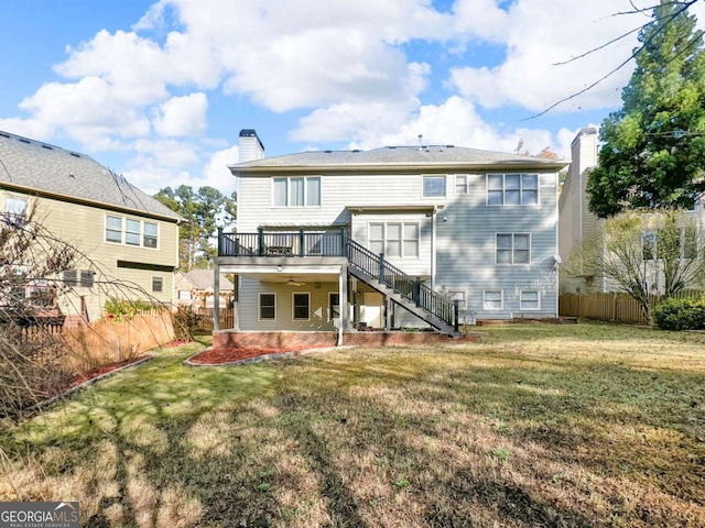 back of house featuring fence, stairs, a chimney, a deck, and a patio