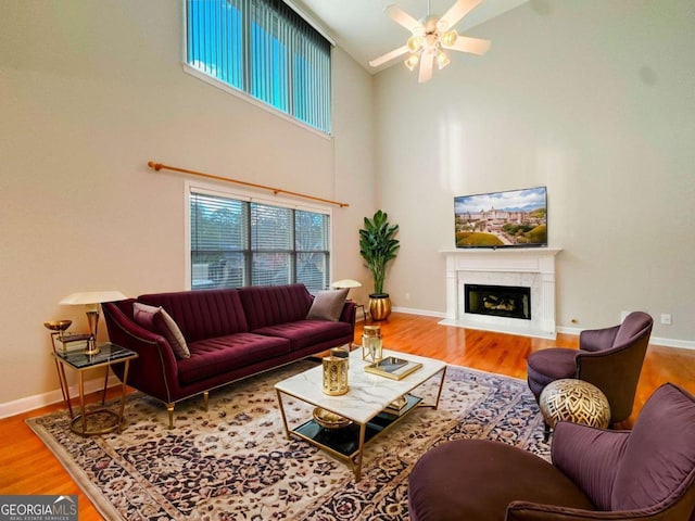 living area with a premium fireplace, baseboards, and wood finished floors